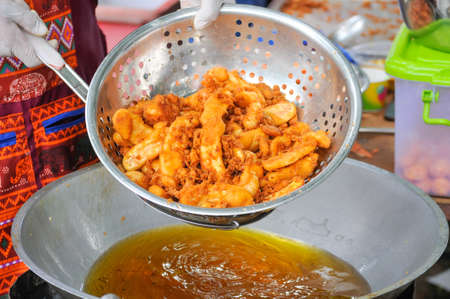 Fried Sweet Potatoes in Colander Over Frying Pan, Thailand Street Food or Thai Snack.の写真素材