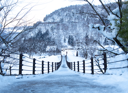 Sling bridge to the mountain in winter season in shirakawago, Japan
