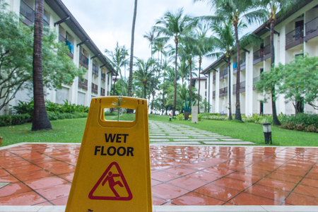 A wet floor sign on a rainy day with beach backgroundの写真素材