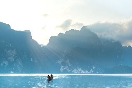A beautiful golden sunrise on the river, boating on the river and beautiful mountainの写真素材