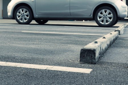 Vacant Parking lot and concrete wheel stop. color toned. gray bronze car.の写真素材