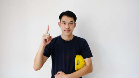 Close front view of male engineering construction worker standing holding safety yellow safety...