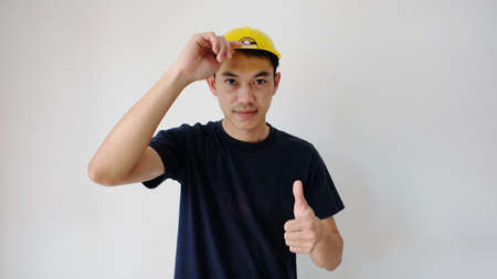 Close front view of male engineering construction worker standing holding safety yellow safety helmet and work safety building exterior backgroundの写真素材