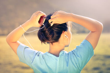 Listening Music - Young girl listening to music at sunset outdoorsの写真素材