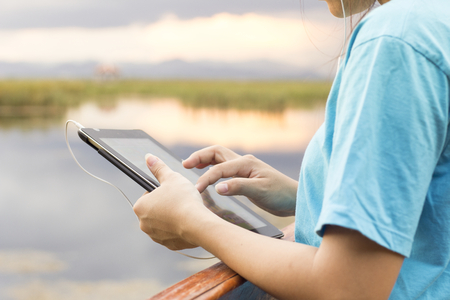 Young Woman Lifestyle Happy Using A Tablet Phone Outdoors , Filtered images color effectの写真素材