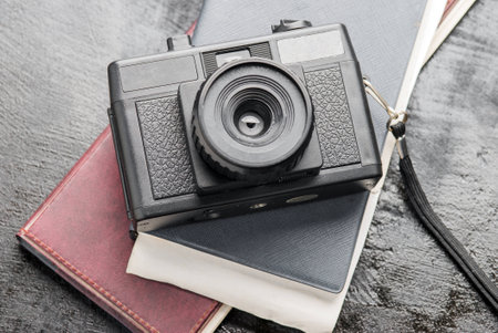 Retro camera and a diary on vintage black wooden backgrounds.