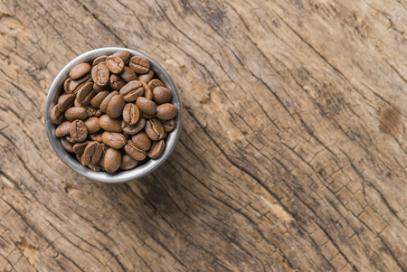 Coffee beans of arabica on texture wooden background.の写真素材