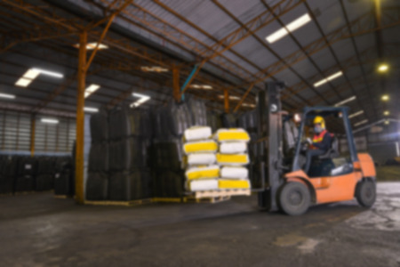 warehousing. Forklift driver stacking pallets with cement packs by stacker loaderの写真素材