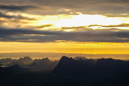 Beautiful Mountain And Sunset. Dark Silhouette of Mountains on Yellow Sunrise Backgroundの写真素材