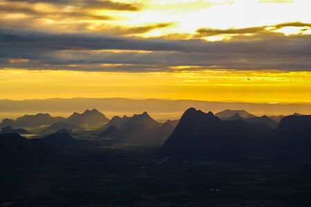 Beautiful Mountain And Sunset. Dark Silhouette of Mountains on Yellow Sunrise Backgroundの写真素材