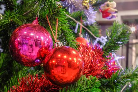 Christmas ball ornaments decoration hanging on fir tree over red circle bokeh blurred night light background with copy space for text, greeting card happy new year 2017の写真素材