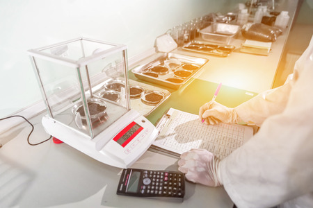 Laboratory research, flask containing chemical liquid with microscopeの写真素材