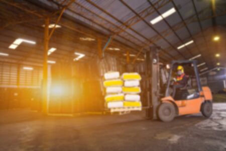 warehousing. Forklift driver stacking pallets with cement packs by stacker loaderの写真素材