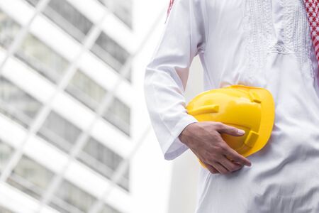 Arab muslim engineer uniform and worker checking construction drawing at construction site. and...