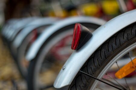 Close-up detail of a bicycle wheel at a public bicycle rackの写真素材
