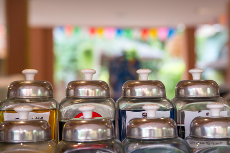 Close-up detail of glass syrup jars with metal lids.の写真素材
