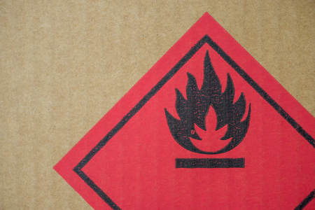 Close-up detail of a fire hazard warning symbol on a cardboard cargo box containing chemicals.の写真素材
