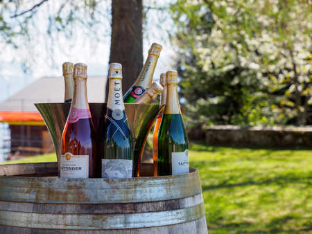 MONTREUX, SWITZERLAND - APRIL 27, 2018: Closeup detail of multiple bottles of luxury Champagne on a barrel at a hotel garden on the alps. Tourism and holidays.のeditorial素材