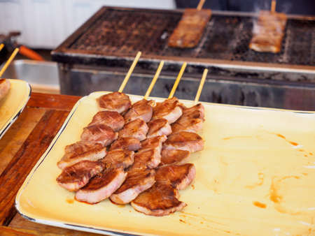 Closeup detail of Yakiniku Kushiyaki flame-grilled beef skewers sold at a street stall. Chiyoda, Tokyo, Japan. Travel and cuisine.の写真素材