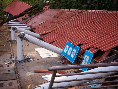 PATHUM THANI, THAILAND - APRIL 27, 2019: Closeup of the broken remains of a covered walkway destroyed by an uprooted tree. Thammasat University Rangsit Campus. Travel and natural disasters.のeditorial素材