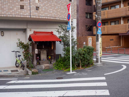 TOKYO, JAPAN - APRIL 1, 2019: Wide angle view of a small Shinto shrine situated between the...