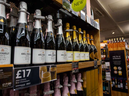 BATH, UNITED KINGDOM - MARCH 5, 2019: Wide closeup of multiple bottles of discount Champagne the shelves of a Marks & Spencer department store. Alcohol and shopping.のeditorial素材
