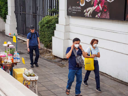 BANGKOK, THAILAND - FEBRUARY 2, 2019: Locals wear P95 face masks while walking in downtown Ratchathewi, due to the toxic PM2.5 smog. Health and pollution.のeditorial素材