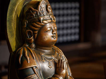 KYOTO, JAPAN - MARCH 29, 2018: Closeup macro detail of a crowned buddha in the Namaskara prayer position. Kiyomizu-Dera Temple, Higashiyama. Travel and religion.のeditorial素材