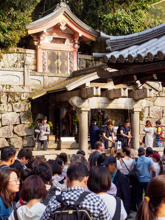 KYOTO, JAPAN - MARCH 29, 2018: Wide vetical view of tourists drinking fron the sacred waters of the Otowa no Taki Waterfall, Kiyomizu Dera, Higashiyama. Travel and holidaysのeditorial素材