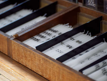 KYOTO, JAPAN - APRIL 2, 2018: Closeup macro detail of a box containing multiple candles with different prayers. Kinkakuji golden pavilion. Travel and religion.のeditorial素材