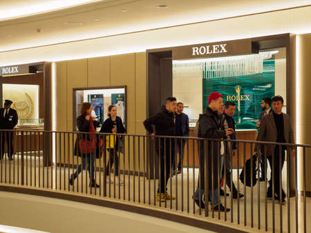 LONDON, UNITED KINGDOM - MARCH 7, 2019: Asian tourists shop for Rolex luxury Swiss watches at the...
