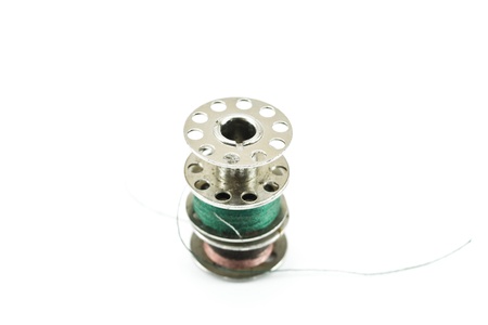 Metal spools of thread on white background