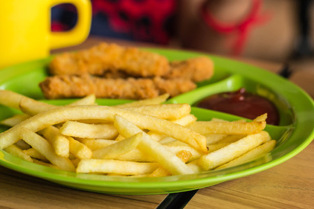 french fries with ketchup on wooden background in a restaurant.