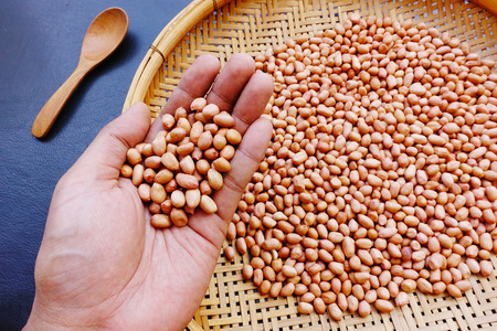 peanut beans with a wooden spoon on black backgroundの写真素材