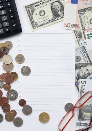 banknote and coin with empty notebook, glasses and calculator for backgroundの写真素材