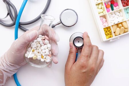 different medication with stethoscope isolated on white backgroundの写真素材