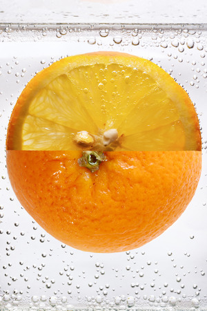 Orange fruit in carbonated soda macro shotの写真素材