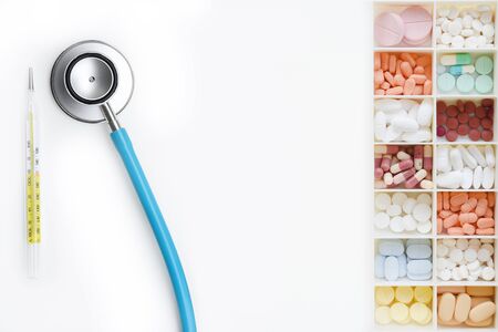Different medication with stethoscope and thermometer on white backgroundの写真素材