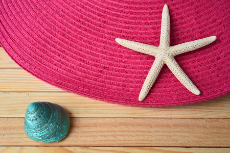 Summer straw hat and starfish on wooden backgroundの写真素材