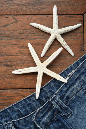 jeans texture and starfish on wooden backgroundの写真素材