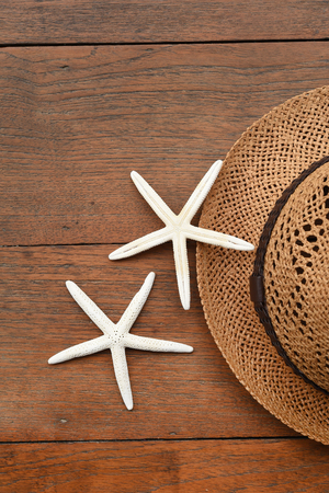 Summer straw hat and starfish on wooden backgroundの写真素材