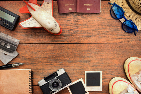Top view of travel accessories with a passport, camera, notebook, glasses on wooden backgroundの写真素材