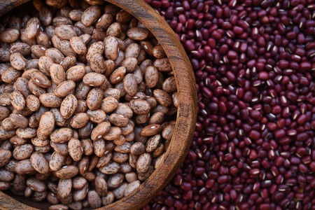 Pinto bean in wooden bowl on red bean background
