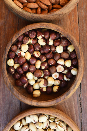 hazelnut and almond with pistachios in wooden bowlの写真素材