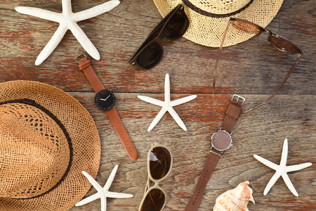 Summer hat and sunglasses with accessories and sandals on wooden backgroundの写真素材