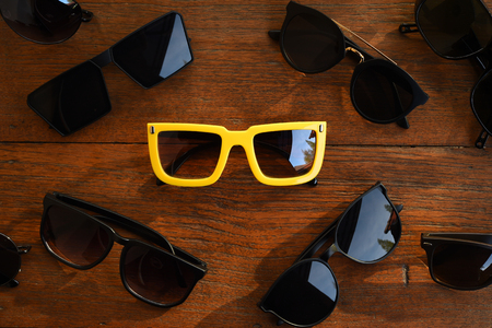 Modern fashionable sunglasses on wood backgroundの写真素材