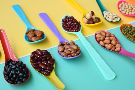 Assortment of beans and lentils in wooden spoon on teak wood backgroundの写真素材