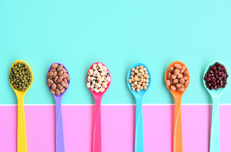 Assortment of beans and lentils in wooden spoon on teak wood backgroundの写真素材
