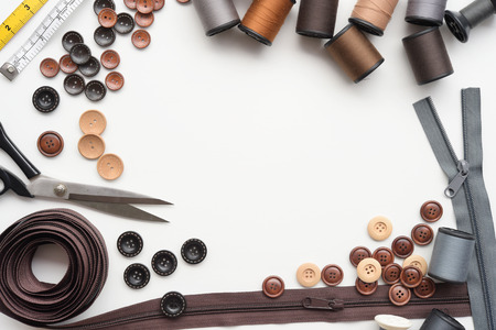Composition with threads and sewing accessories on white background