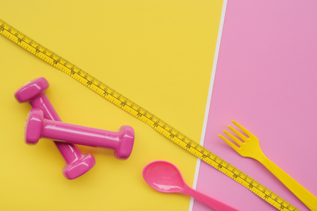 close up of spoon in tape measure with dumbbell for backgroundの写真素材